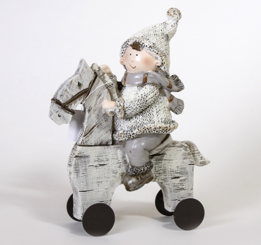 Winterkind Junge auf einem Schaukelpferd 20,5x16x6 cm